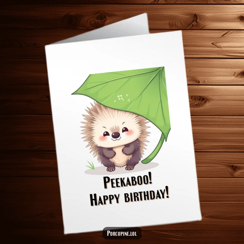 Funny Free Printable Birthday Card: A porcupine with a shy, sweet smile peeks out from behind a large green leaf, ready to celebrate.
