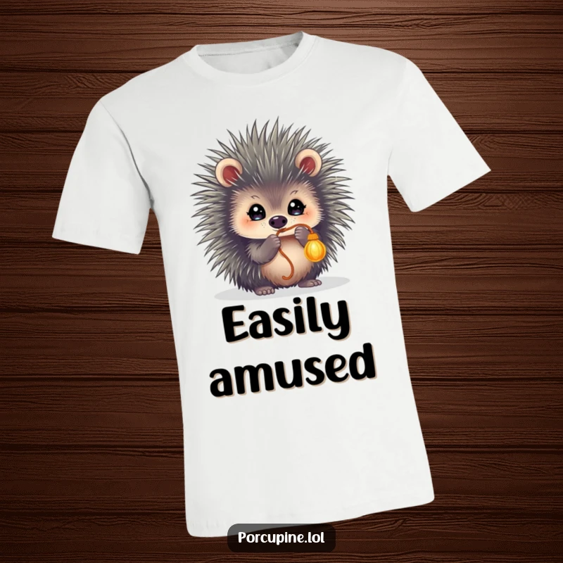 Funny t-shirt showcasing a porcupine with wide, sparkling eyes, actively batting at a dangling string with playful intensity.